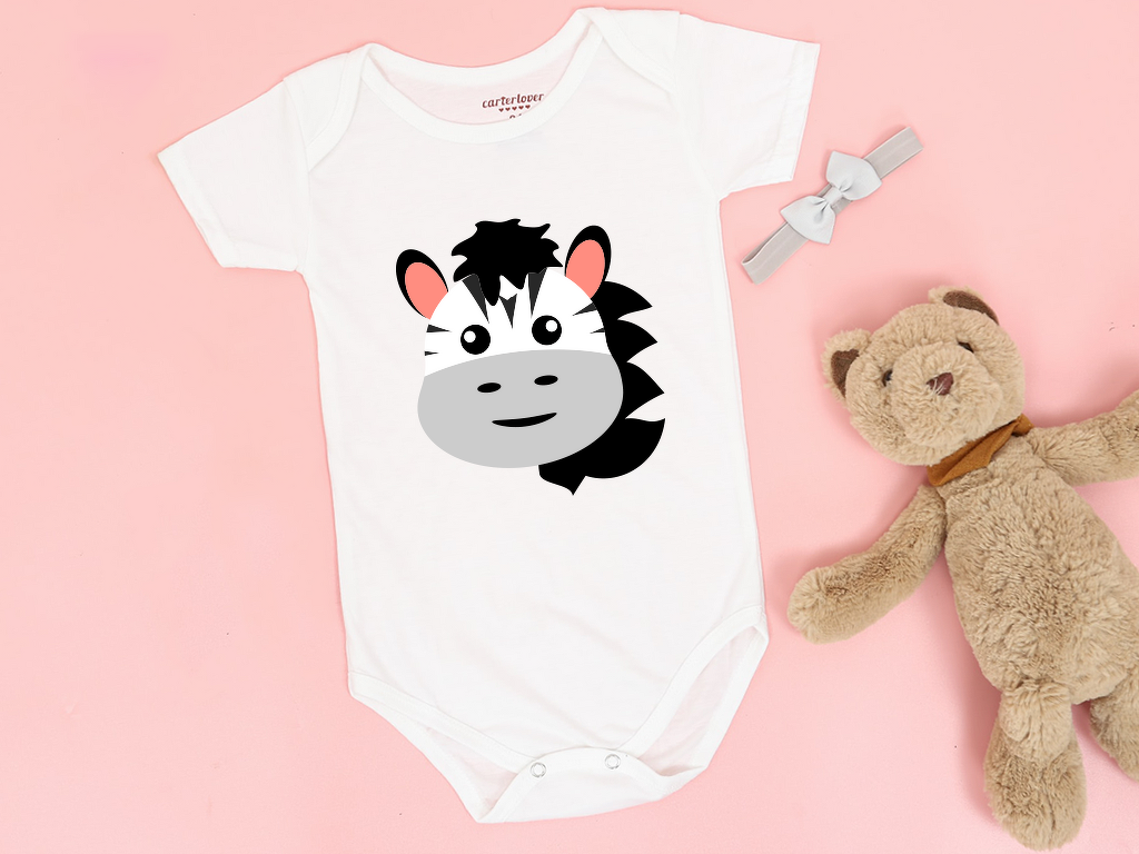 Weißer Baby-Body mit großem Zebrakopf-Plott, auf rosa Hintergrund mit Haarband und Teddybär als Requisite