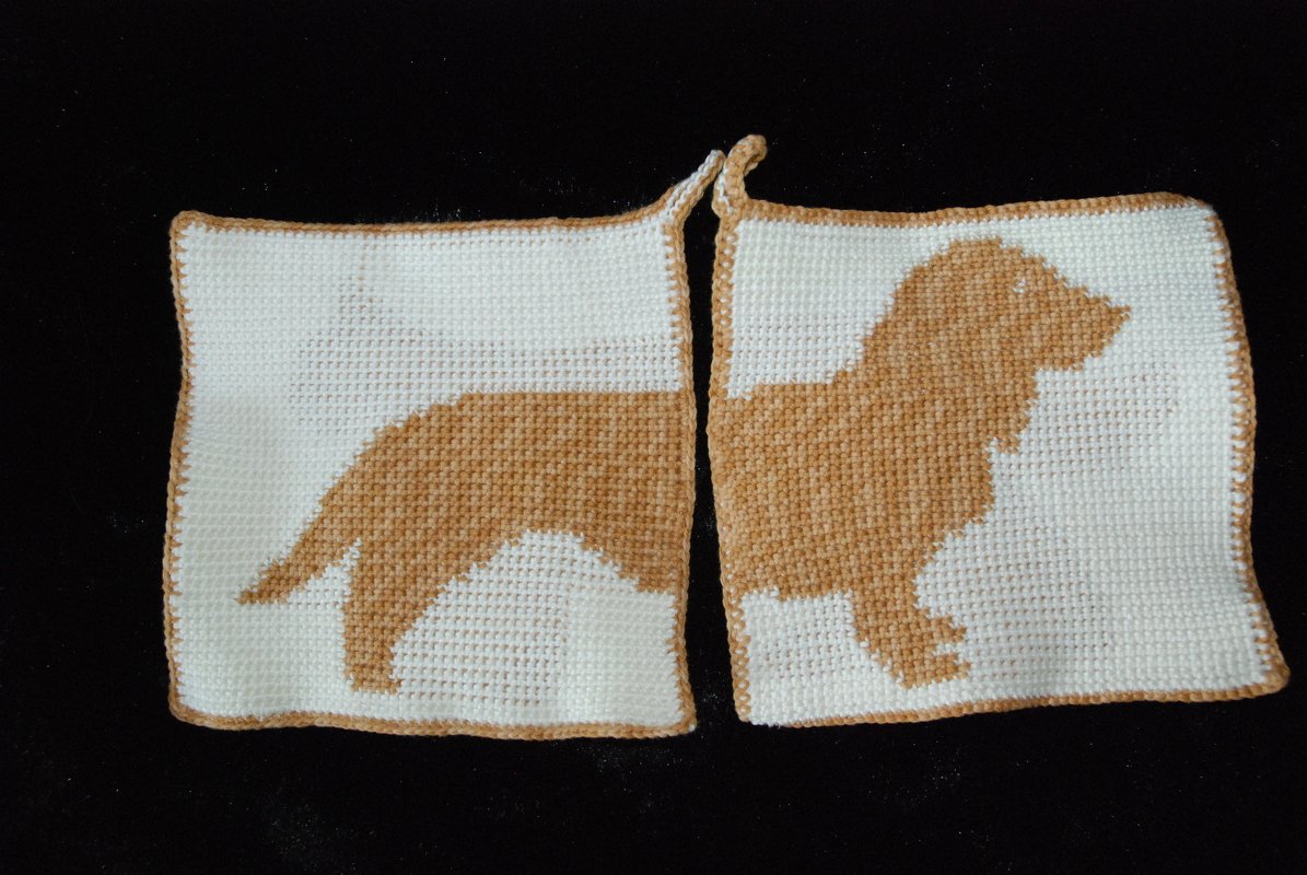 Two square white crochet potholders forming a tan dog silhouette with tan edging and hanging loops