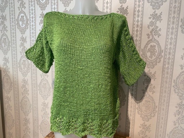 Grüner Damen-Strickpullover auf Mannequin, U-Boot-Ausschnitt, kurze Ärmel, gelochter Saum