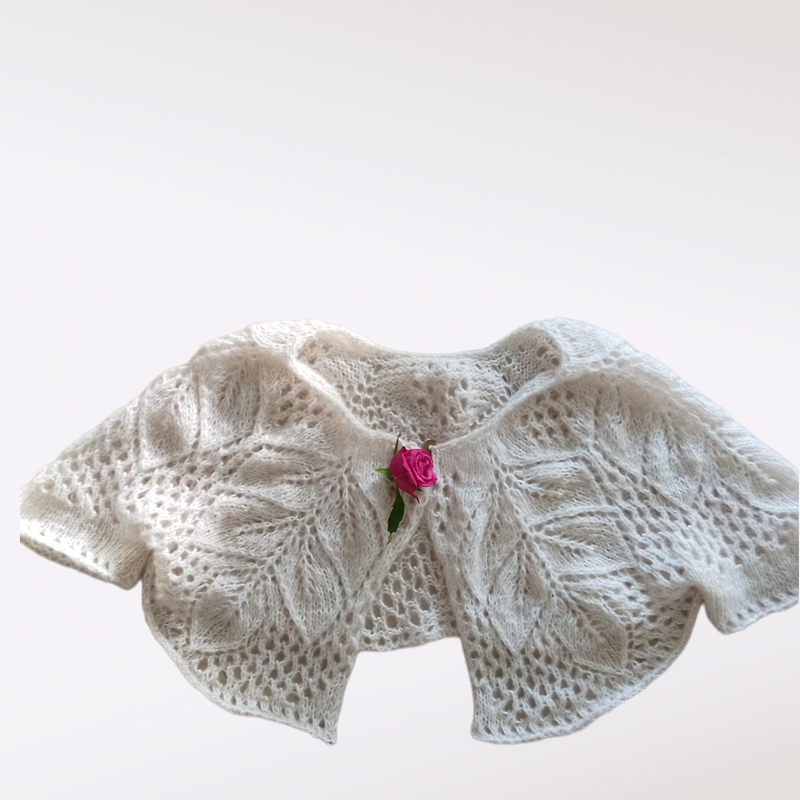 Cremefarbener kurz geschnittener Strickbolero mit Blattspitzenmuster und rosa Rose am Verschluss
