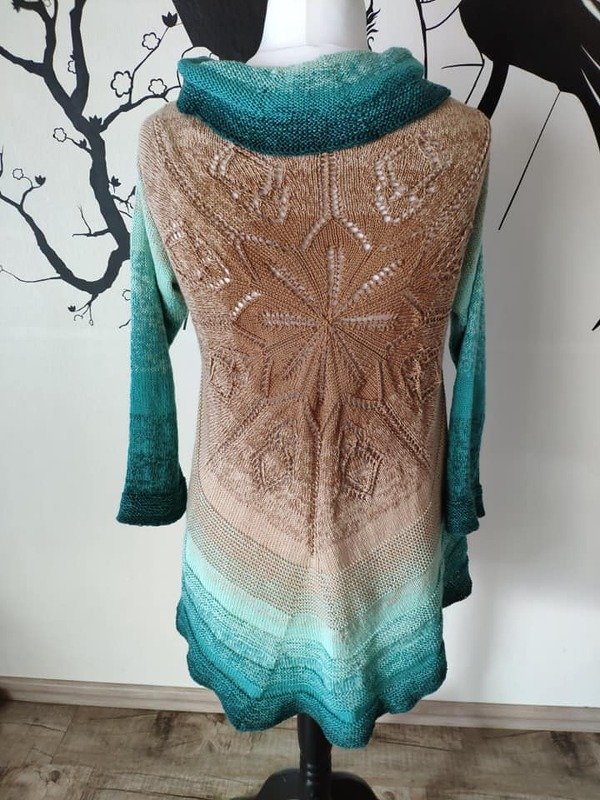 Rückansicht eines gestrickten Damen-Cardigans mit Verlaufsgarn in Türkis bis Beige und großem sternförmigem Lacemuster