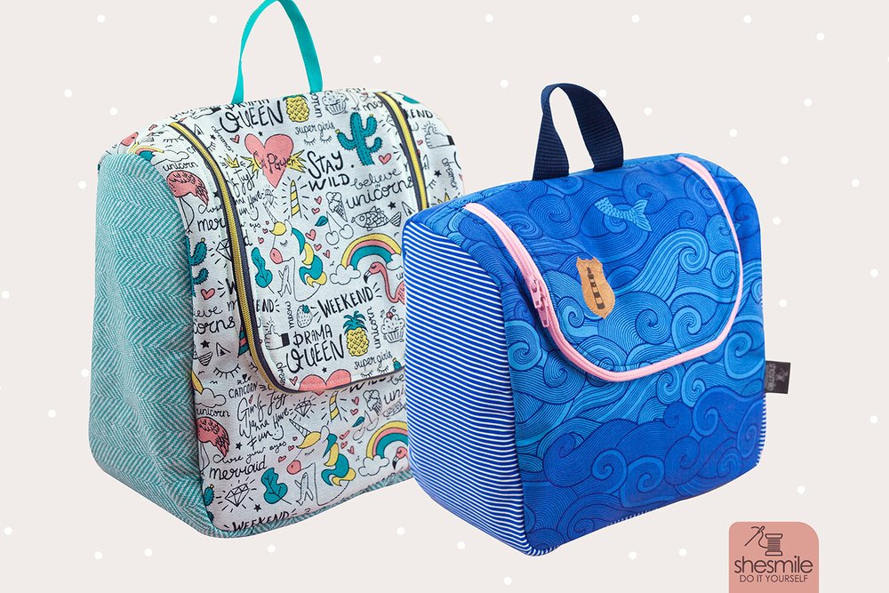 Zwei genähte Stofftaschen mit Reißverschluss: eine mit Einhorn- und Regenbogenmotiven, eine mit blauem Wellendesign und Leuchtturm