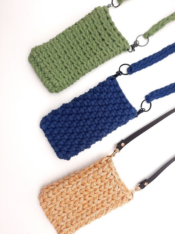 Drei kompakte, gehäkelte Umhängetaschen in Grün, Blau und Beige mit abnehmbaren Tragebändern