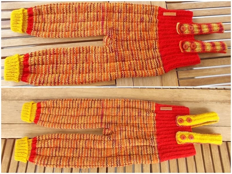 Gestrickte Babyhose mit Trägern in Orange, Gelb und Rot auf Holzuntergrund