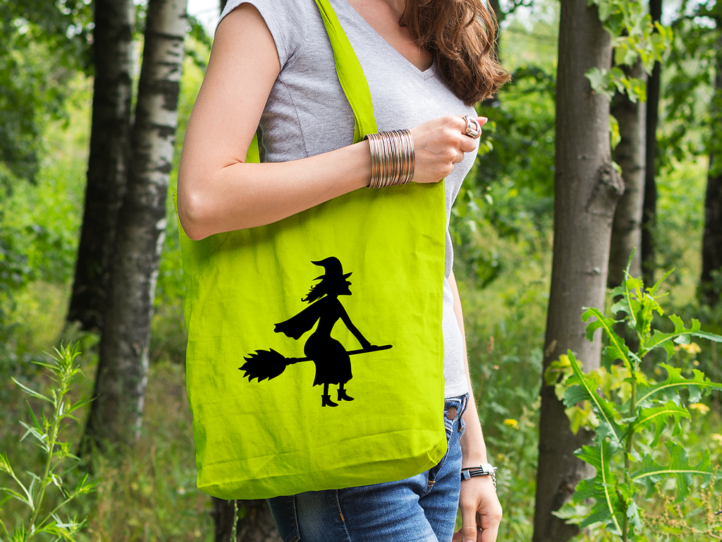 Grüne Tragetasche mit schwarzer Silhouette einer Hexe auf ihrem Besen