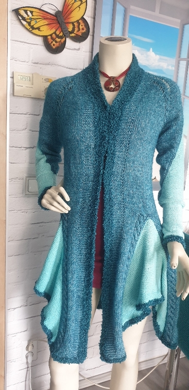 Langer, offener Damen-Cardigan in Petrol mit helltürkisfarbenen Einsatzflächen auf einem Mannequin