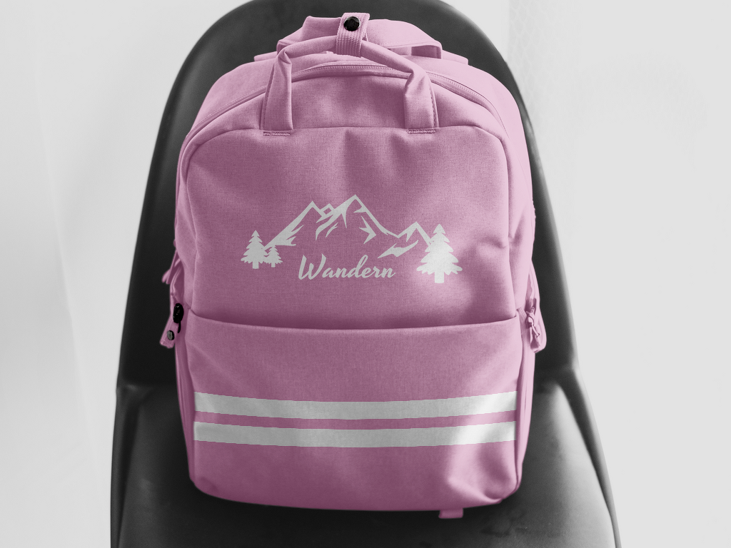 Pinker Rucksack, personalisierbar mit weißem Plottermotiv (Berge, Tannen, „Wandern“) und reflektierenden Streifen