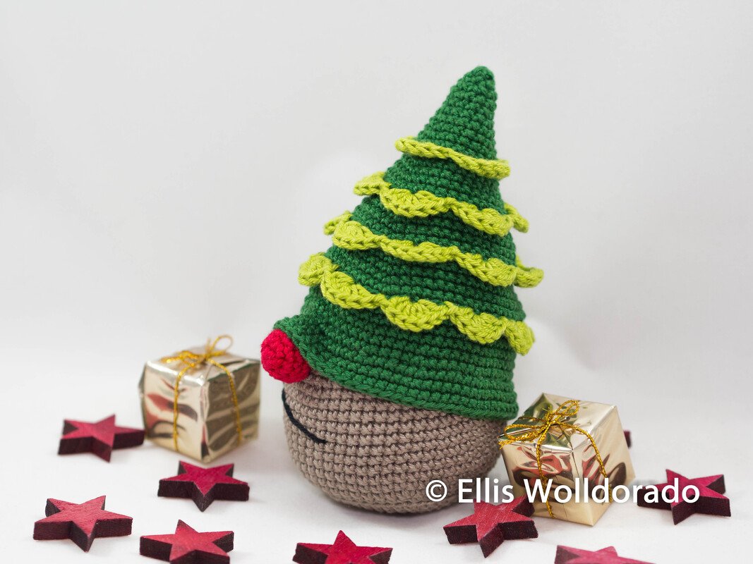 Gehäkelter Amigurumi-Wichtel in Weihnachtsbaumform mit roter Nase, Geschenkpaketen und roten Sternen