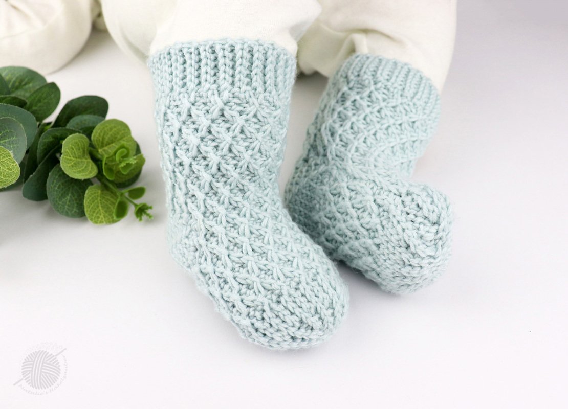 Gehäkelte hellmintfarbene Babysocken mit Rippbündchen und Strukturmuster
