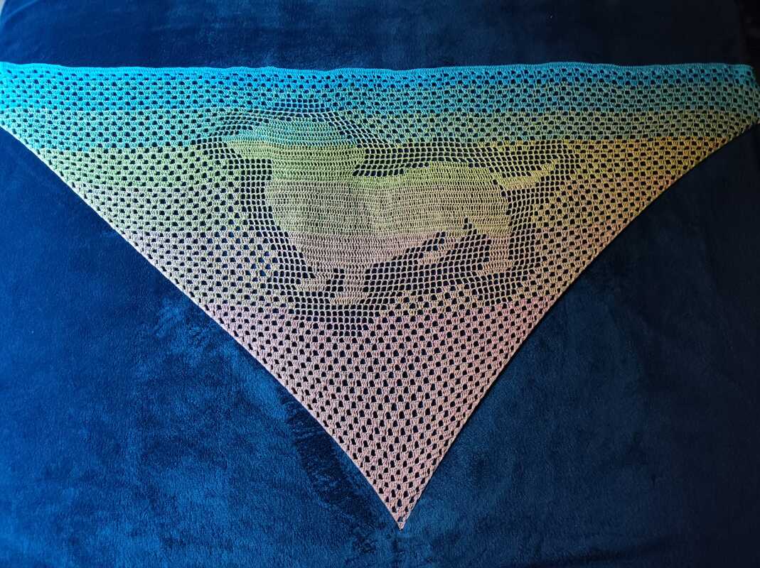 Dreieckiges Filet-Häkeltuch mit laufender Hundesilhouette und Farbverlauf auf dunkelblauem Hintergrund