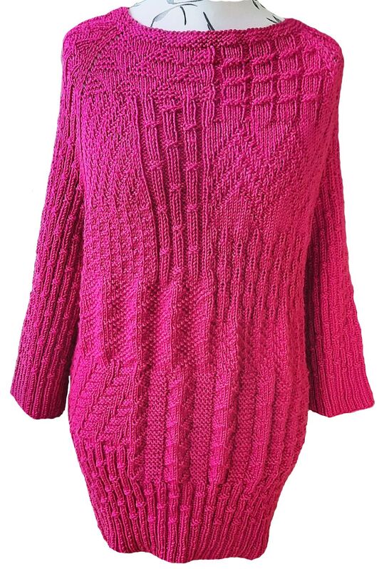 Langer, locker geschnittener pinker Damenpullover mit verschiedenen Strickmustern, Frontansicht auf Schaufensterpuppe