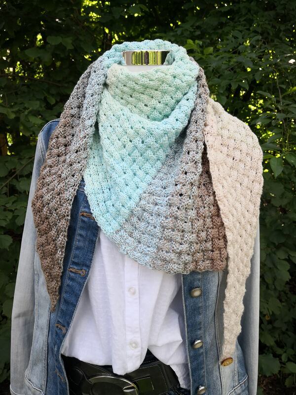 Gestricktes Dreieckstuch in Mint-, Blau- und Beigetönen mit wabenartiger Struktur auf Schaufensterpuppe mit Jeansjacke