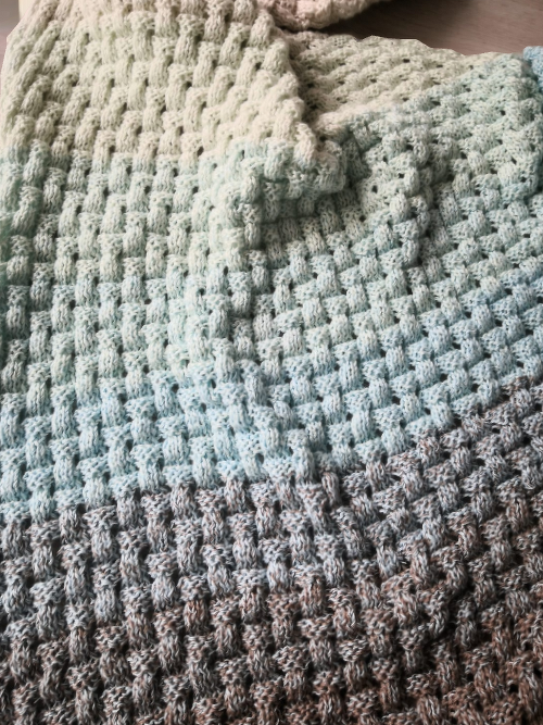 Gestricktes Dreieckstuch mit Farbverlauf von Mint über Hellblau zu Grau und ausgeprägtem Korbgeflechtmuster.
