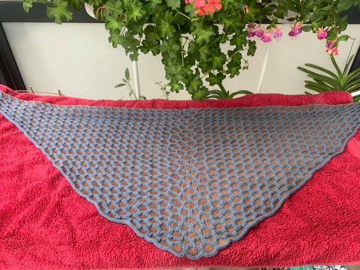 Blaugraues Dreieckstuch mit offenem Wabenmuster auf rotem Untergrund