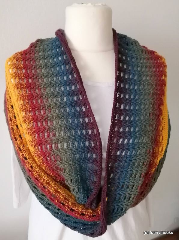Multicolor crocheted loop scarf (cowl) on a white torso mannequin, showing an open stitch pattern and gradient colors.