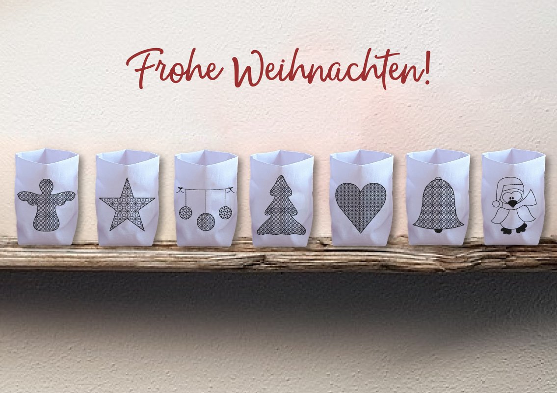 Sieben weiße Hüllen für LED-Tischlichter mit gestickten Weihnachtsmotiven auf einem Holzregal.