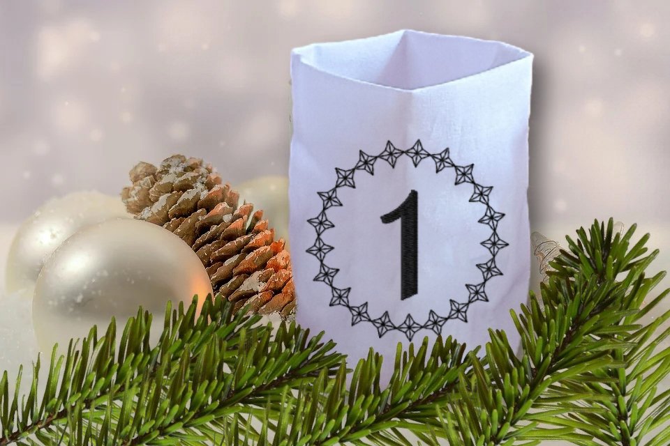 Weiße Hülle mit gestickter Zahl 1 im Sternkranz, Tannenzweig, Zapfen und silberne Kugeln