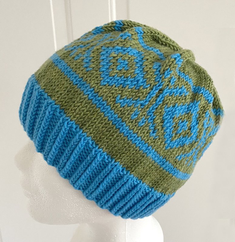 Gestrickte Mütze in Türkis und Oliv mit geripptem Bündchen und Rautenmuster auf Schaufensterkopf