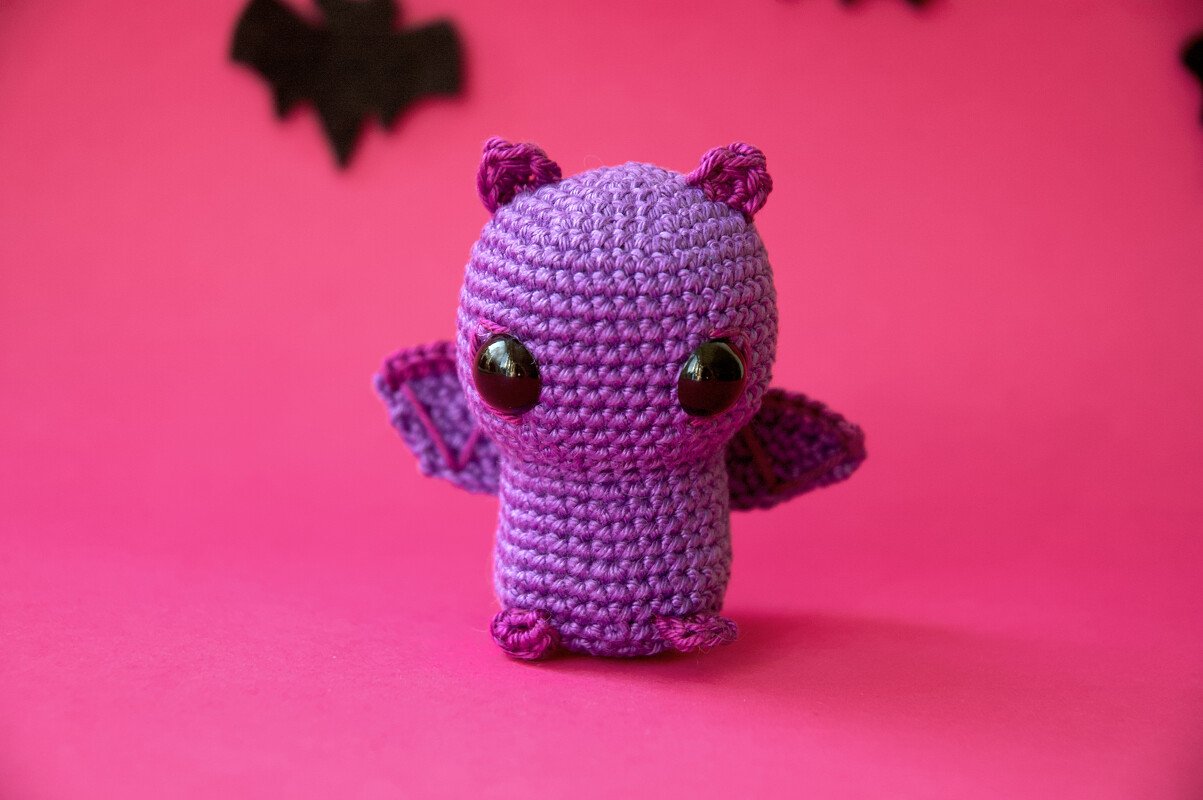 Lila gehäkelte Amigurumi-Fledermaus mit großen schwarzen Augen