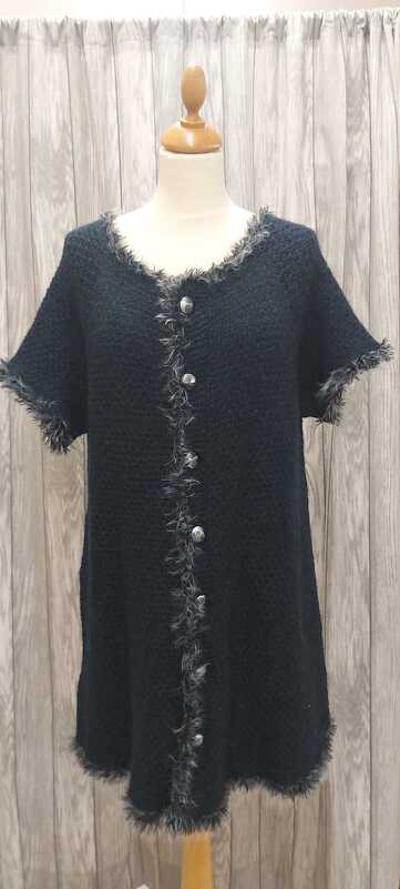 Lange schwarze Strickjacke mit Knopfleiste und flauschigem Fransenbesatz auf Schaufensterpuppe