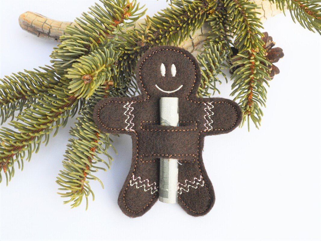 Brauner Filz-Lebkuchenmann mit Schlitz für einen Geldschein an einem Zweig