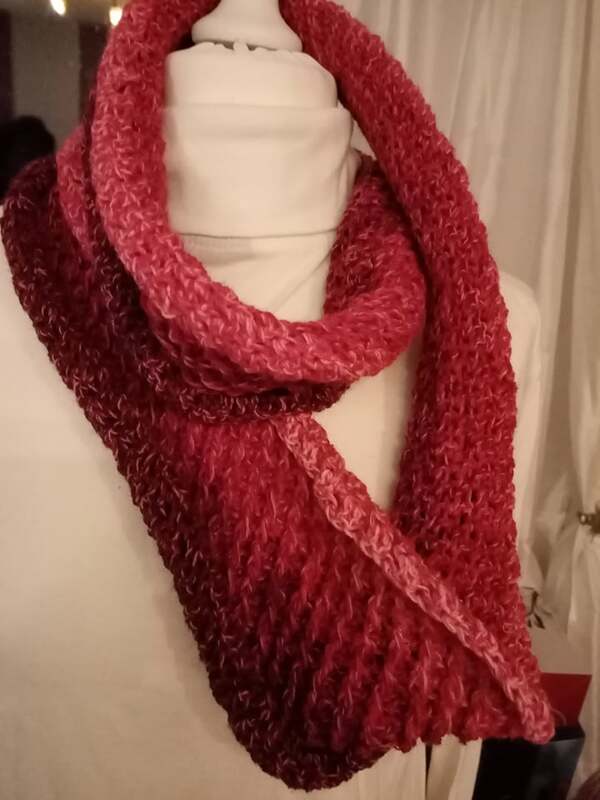 Gehäkelter Loop-Schal in Rot- und Rosatönen auf Büste