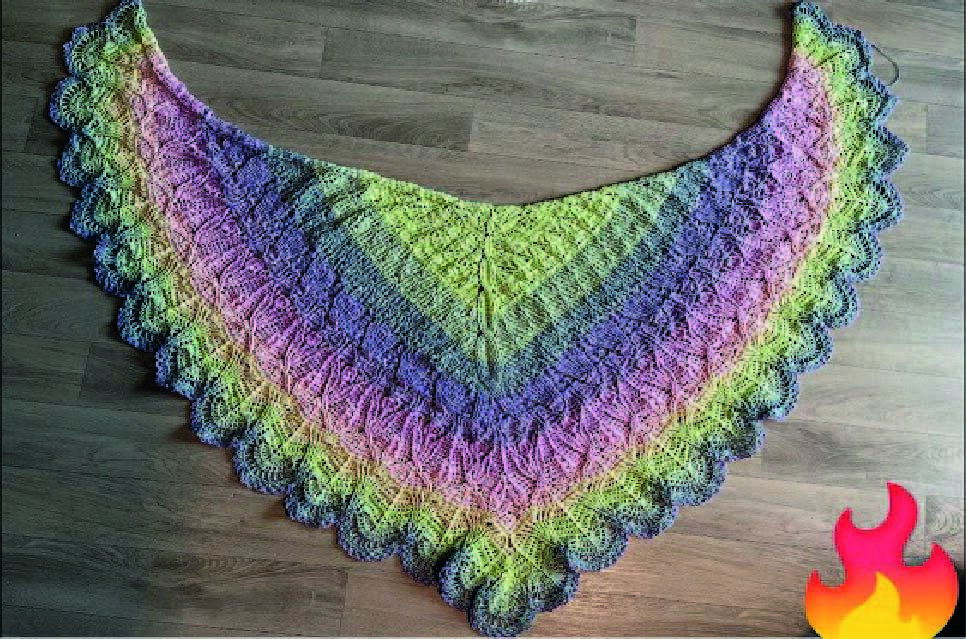 Gehäkeltes Dreieckstuch in Pastellfarben mit Muschelrand auf Holzuntergrund