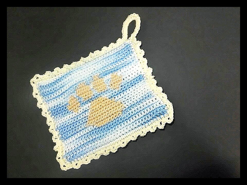 Quadratischer gehäkelter Topflappen hellblau-weiß mit hellbeiger Pfote und Aufhängeschlaufe