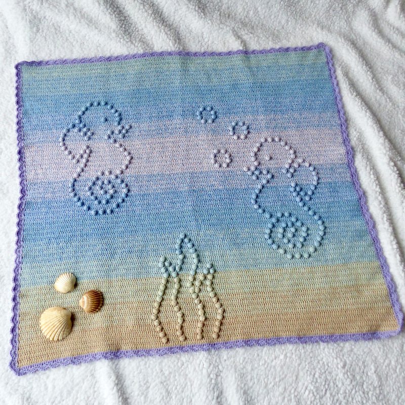 Handgehäkelte Babydecke mit Seepferdchen-Relief, Pastellfarbverlauf und lila Rand