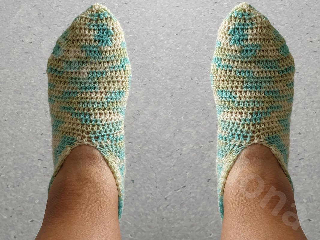 Gehäkelte Socken in Türkis und Creme, getragen und von oben fotografiert.