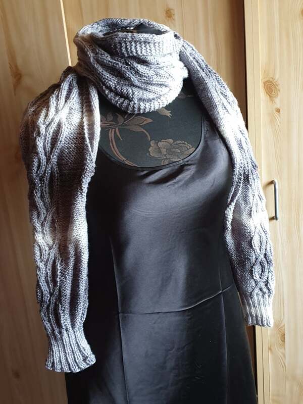 Gestrickter Damen-Bolero in Grau-Weiß mit Zopfmuster auf einer Schneiderpuppe