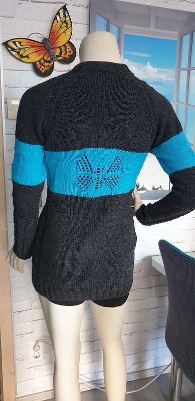 Rückenansicht eines dunkelgrauen Damen-Strickpullovers mit breitem türkisfarbenem Querstreifen und Schmetterlings-Lochmuster