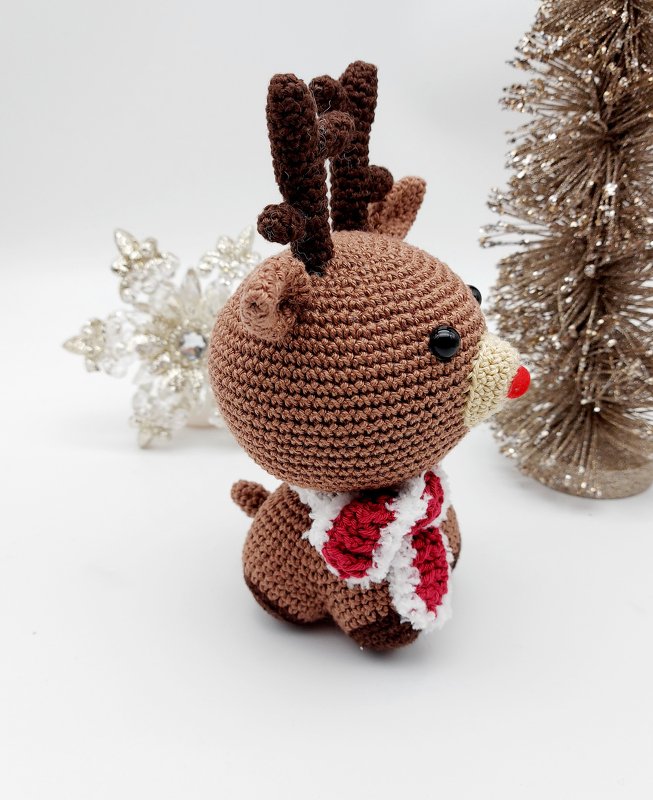 Gehäkeltes Rentier-Amigurumi mit roter Nase und gestreiftem Schal, Seitenansicht