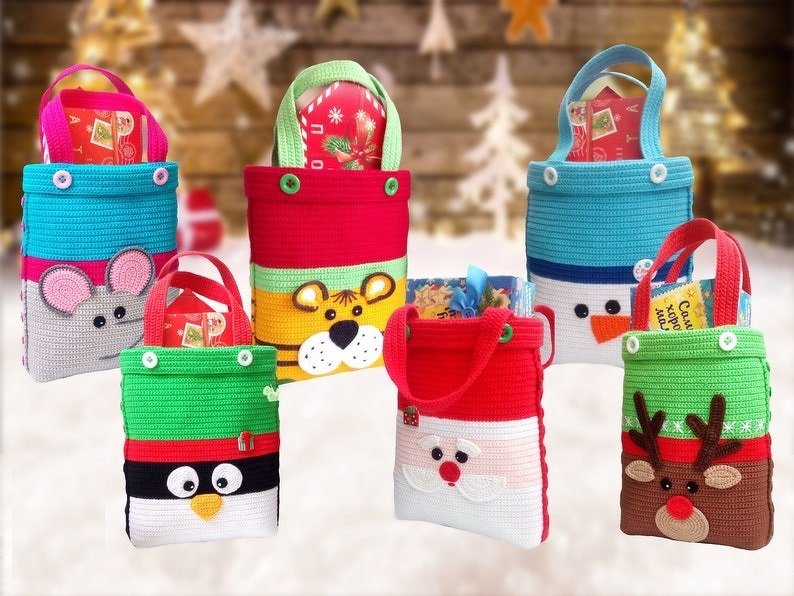 Sechs bunte gehäkelte Geschenkbeutel mit Tier- und Weihnachtsmotiven, gefüllt mit kleinen Geschenken