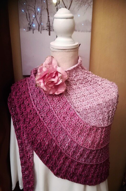 Asymmetrisches gehäkeltes Dreieckstuch in abgestuften Rosa- und Burgundtönen auf einer Schaufensterpuppe