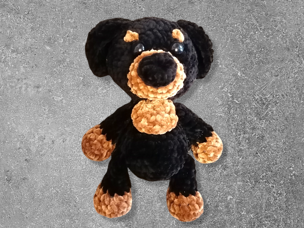 Schwarz-brauner gehäkelter Amigurumi-Hund mit großen Augen