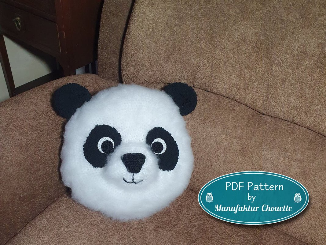 Gehäkeltes Panda-Kopf-Kissen schwarz-weiß auf braunem Sofa