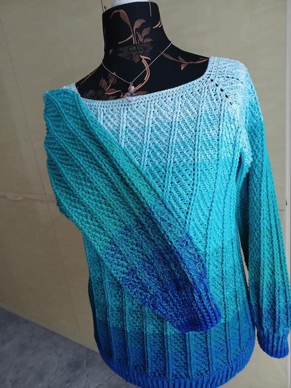 Gehäkelter Damenpullover in Blau-Türkis mit Ajourmuster auf Schneiderpuppe