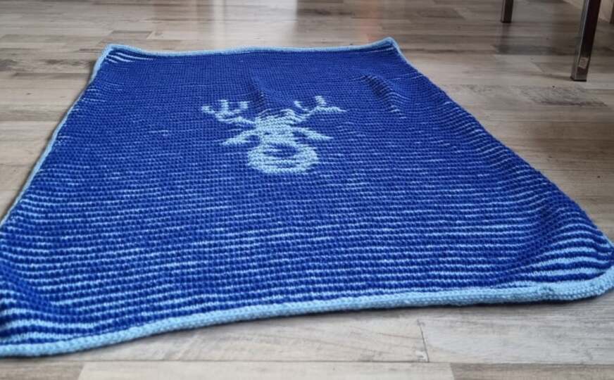 Gestrickte Babydecke mit Elchmotiv