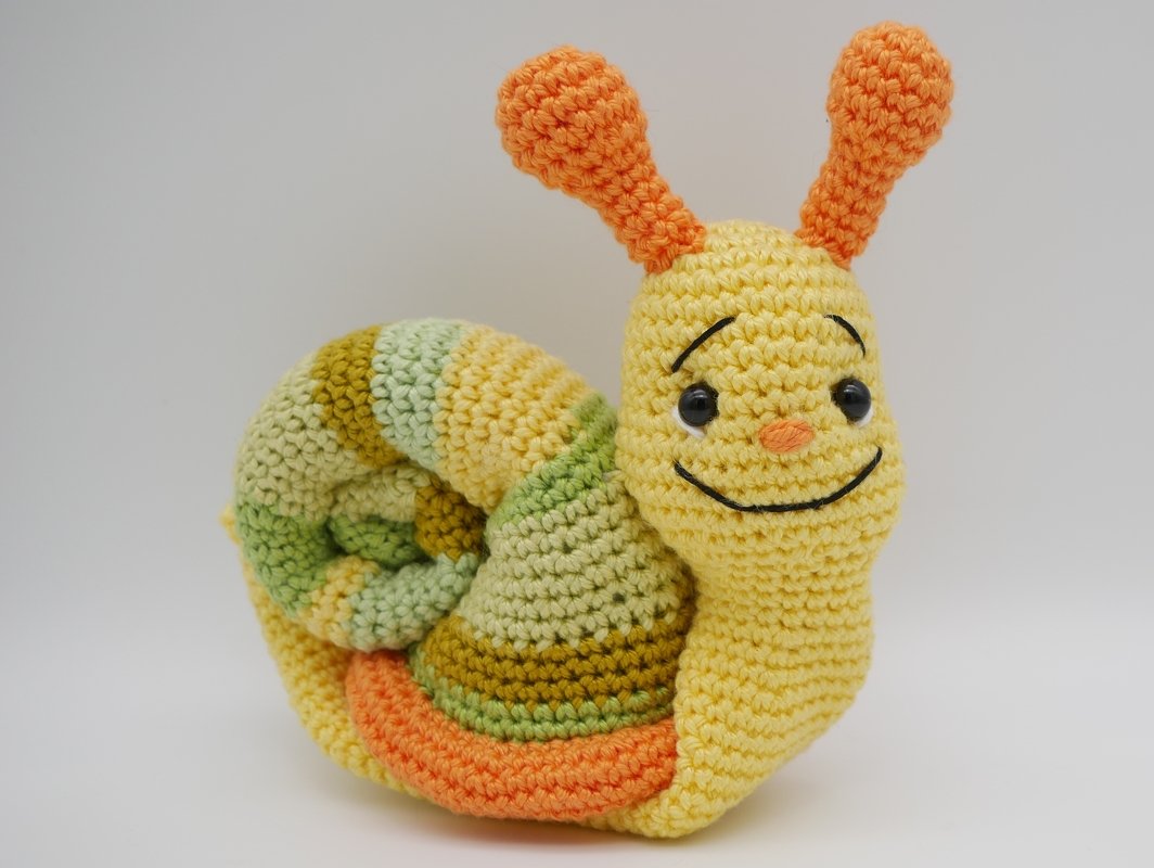 Gehäkelte Schnecke Amigurumi gelber Körper gestreifte Schale