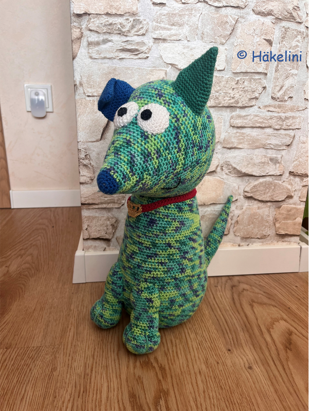 Gehäkelter Amigurumi Hund in melierten Grün- und Blautönen mit rotem Halsband