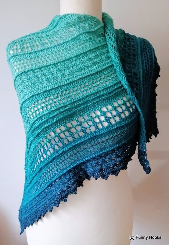Teal-to-navy crochet triangle shawl with lace panels and ridged rows draped on a mannequin