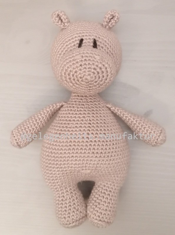 Gehäkeltes rosa Amigurumi‑Nilpferd mit gestickten Augen und runder Schnauze.