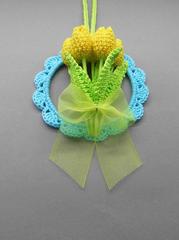 Crocheted yellow tulips in blue scalloped hoop with green organza bow