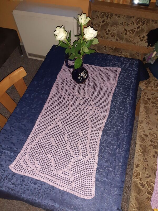 Rosa Filet‑Häkel‑Tischläufer mit Hasenmotiv und Vase mit weißen Rosen