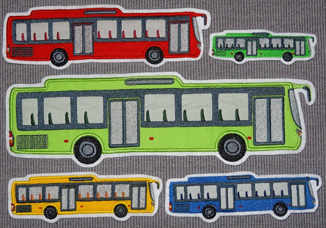 Gestickte Bus-Applikationen in Rot, Hellgrün, Gelb und Blau auf grauem Stoff