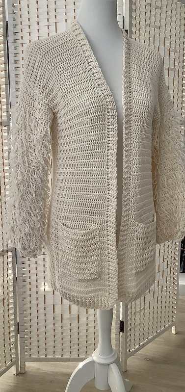 Cremefarbene, hüftlange Häkeljacke offen mit aufgesetzten Taschen auf Schaufensterpuppe