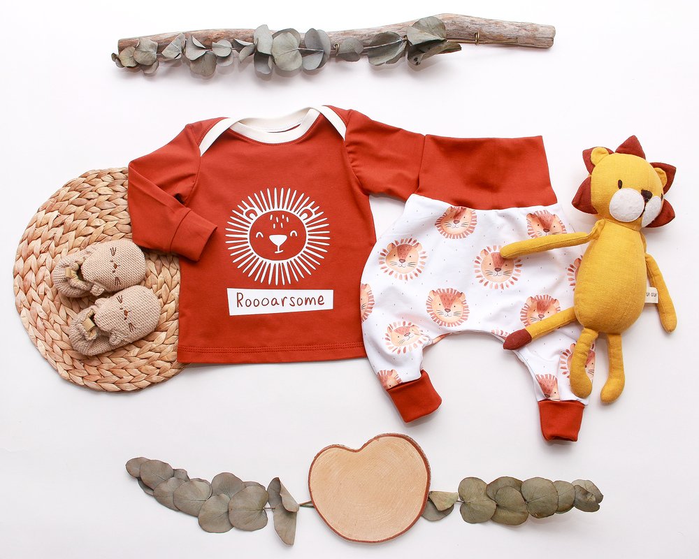 Babyshirt in Rostrot mit Lwengesicht und passende Hose mit Lwenmustern, Plschlwe und Babyschuhe