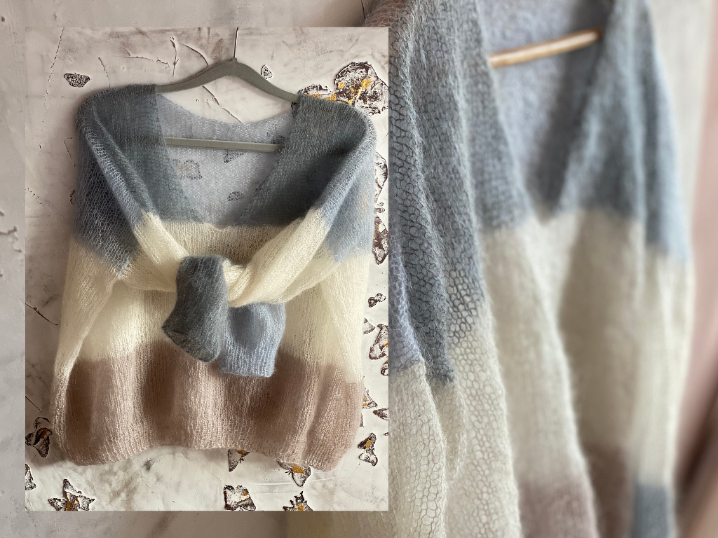 Pale blue, cream, and light brown striped fuzzy knit sweater tied at the front on a hanger.