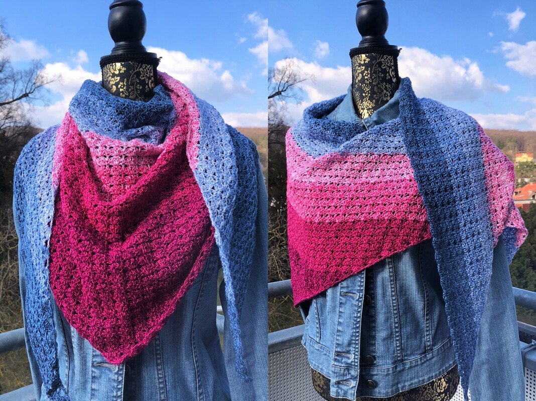 Gehäkeltes Dreieckstuch in Pink- und Blautönen mit Lochmuster an einer Schneiderpuppe über einer Jeansjacke.